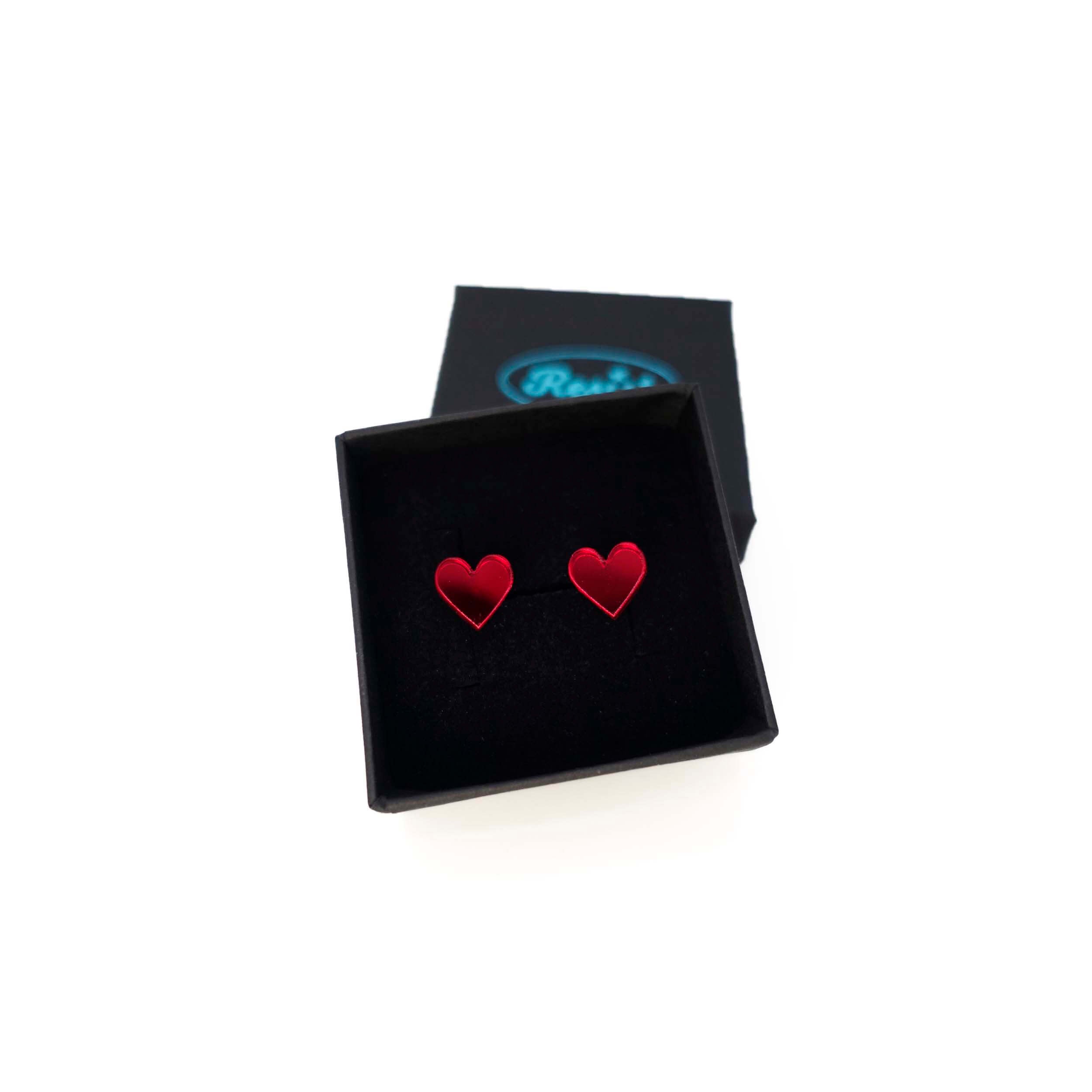 Crimson mirror tiny heart stud earrings shown in a Wear and Resist gift box. 