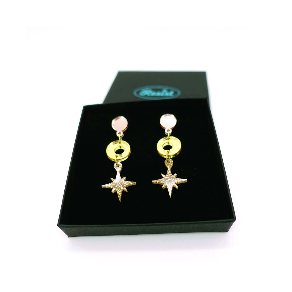 Warm gold tone Deco Star drop earrings shown in a Wear and Resist gift box. 