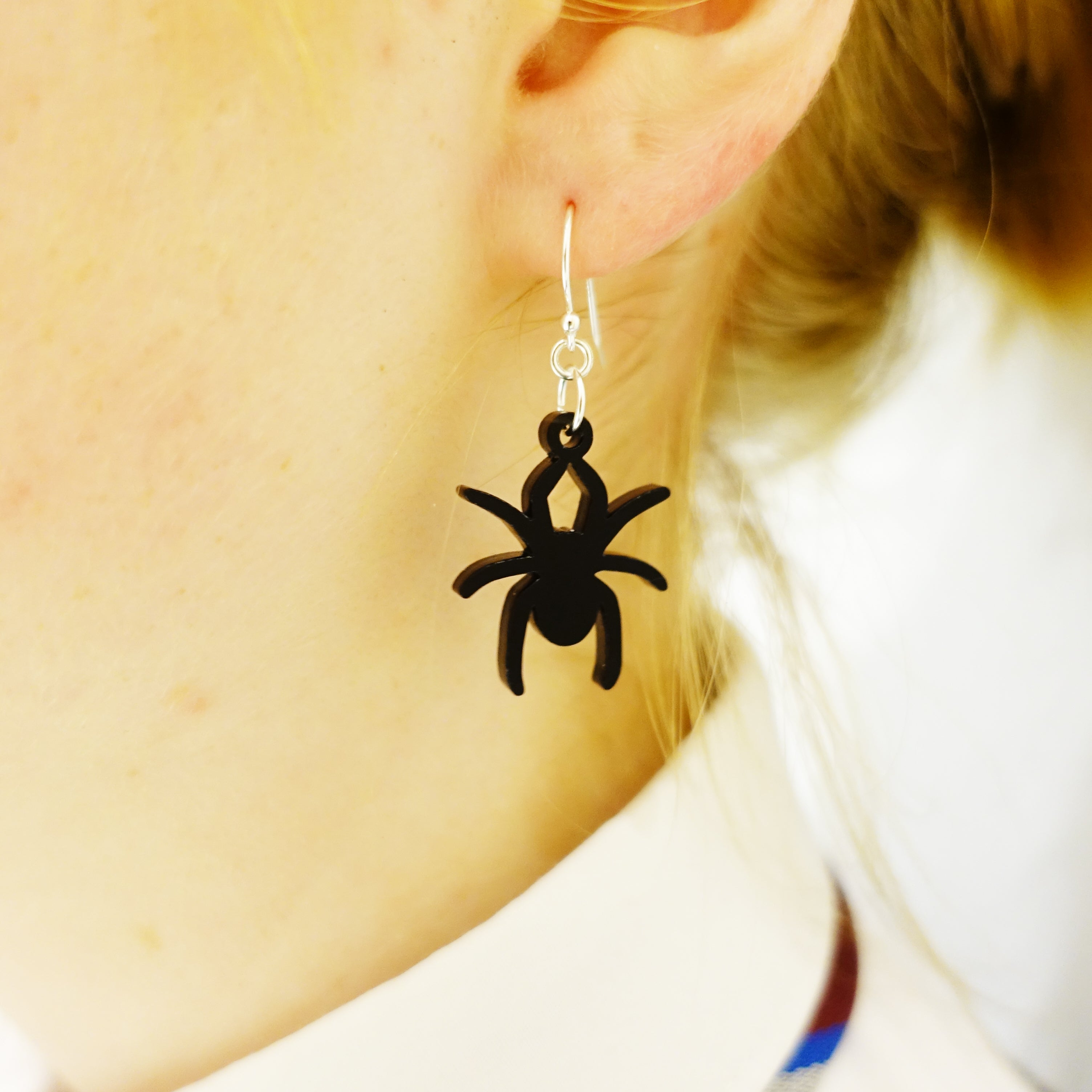 Model wears black Lady Hale commemorative spider earrings.