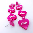 F*ck This Sh*t Valentine's earrings by Wear and Resist, made in magenta acrylic, shown lying down. 