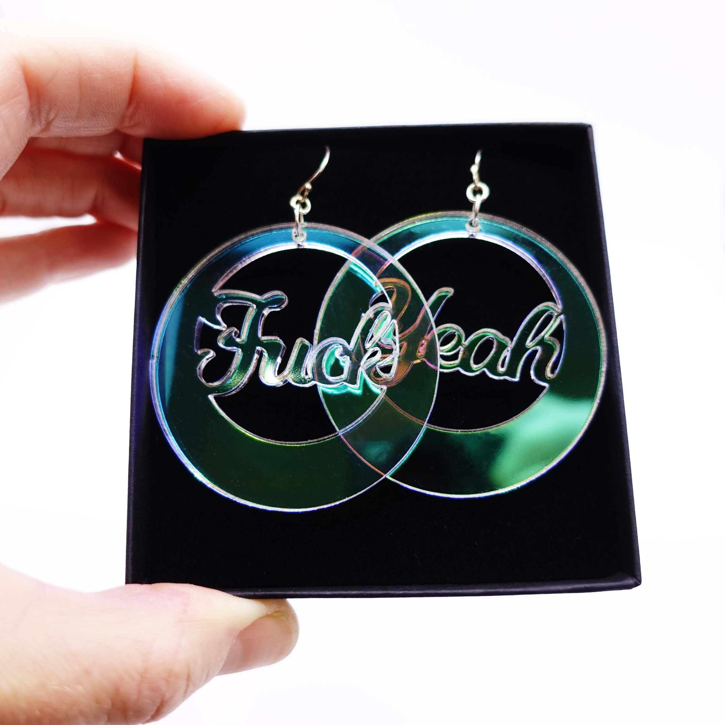 F*ck Yeah iridescent hoop earrings shown held up in a Wear and Resist gift box. 