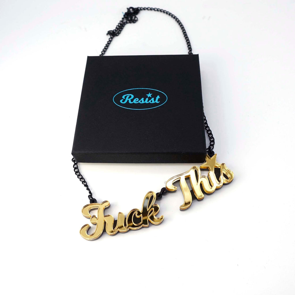 A gold mirror F*ck This necklace shown with a Wear and Resist gift box. 