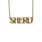 Gold glitter Shero necklace hanging against a white background. 