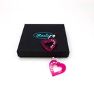 Transparent hot pink I love me heart hoops shown with a Wear and Resist gift box. Throughout February and March, £2 from all heart hoop earrings will go to the D.E.C. (Disasters Emergency Committee) Turkey-Syria Earthquake Appeal. 