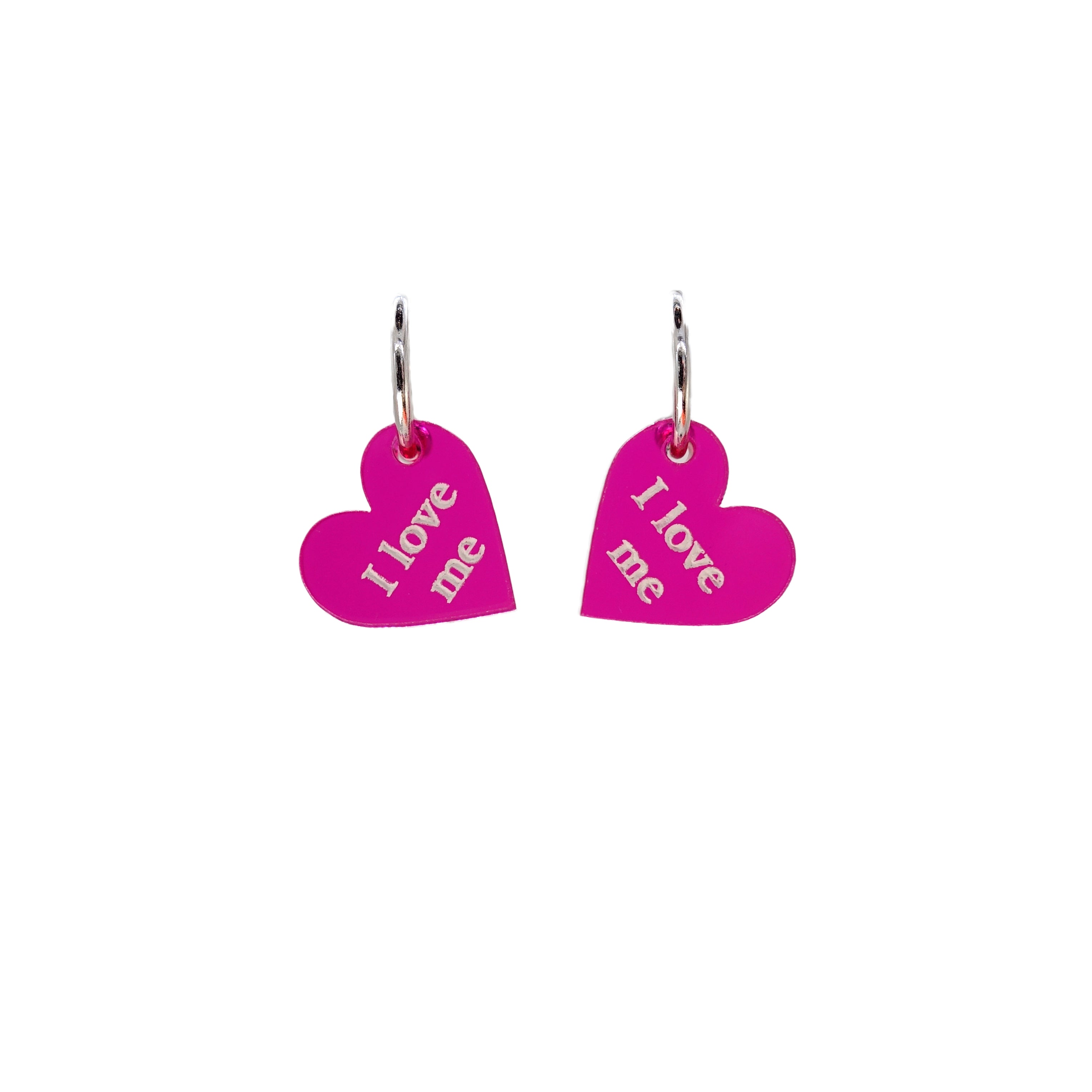 Small I Love Me etched heart earrings in transparent hot pink on sterling silver plated hoops. 