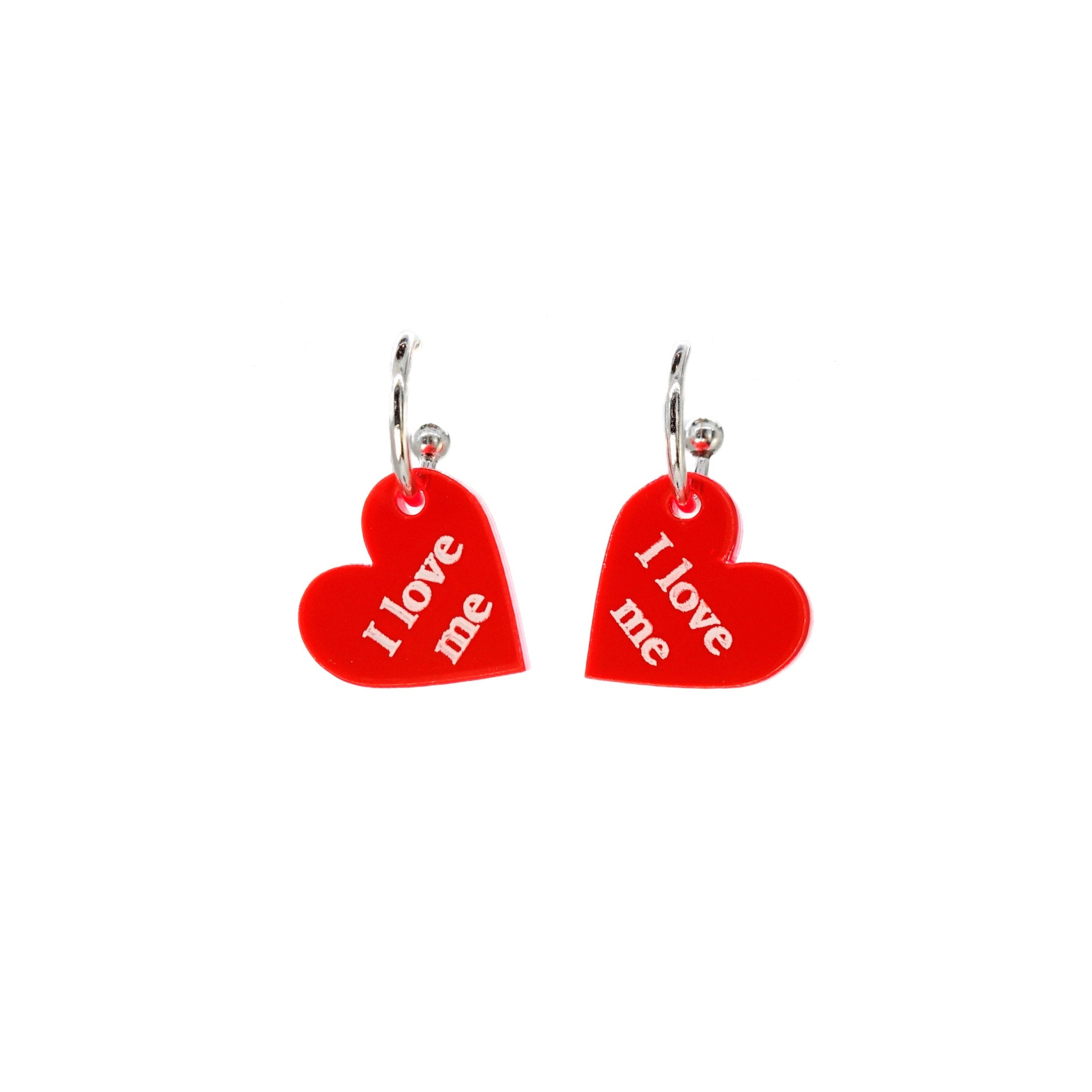 Small heart hoop earrings in hot red, etched with the words 'I love me' on silver plated hoops, shown against a white background. 