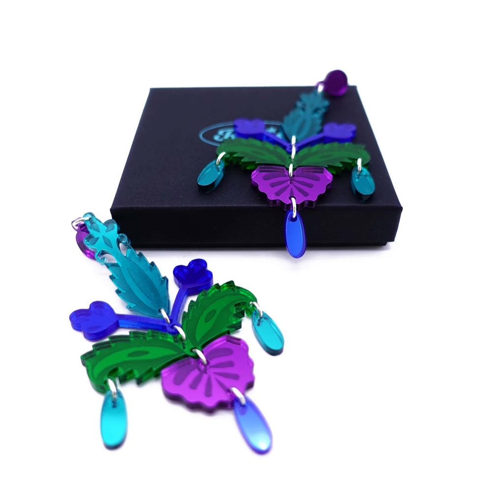 Teal, purple and green Midnight Festival drop earrings shown on a Wear and Resist gift box. 