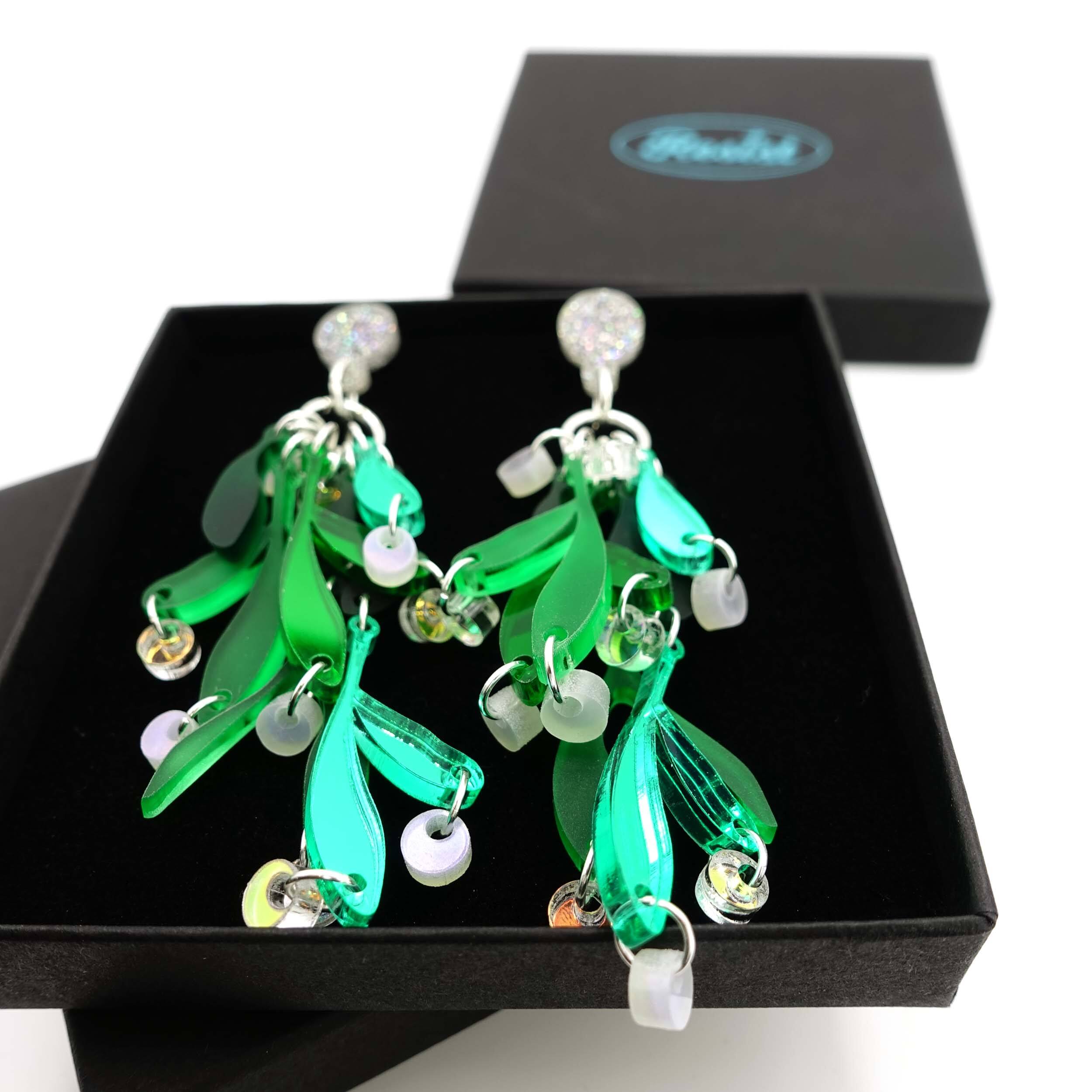 A close up of Mistletoe earrings in a Wear and Resist gift box. 