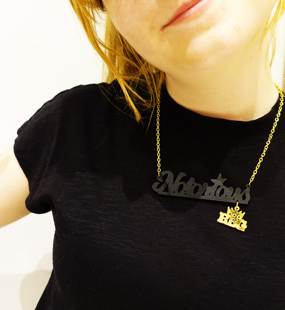 Model wears Notorious RBG necklace in matte black and gold in honour of Ruth Bader Ginsburg
