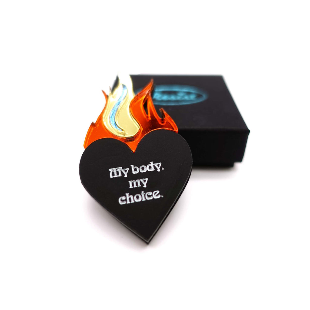 My body my choice flaming heart brooch designed by Sarah Day for Wear and Resist shown with a gift box. 