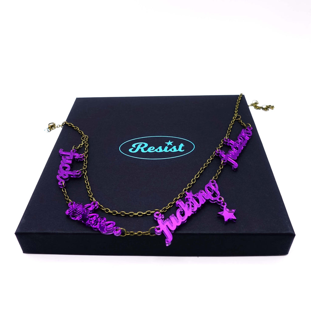 Poison lies F*ck These F*cking F*ckers necklace shown on a Wear and Resist large gift box. 