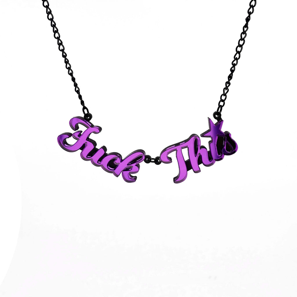Purple mirror F*ck This necklace shown hanging against a white background. Designed by Sarah Day for Wear and Resist. £2 goes to Bloody Good Period. 
