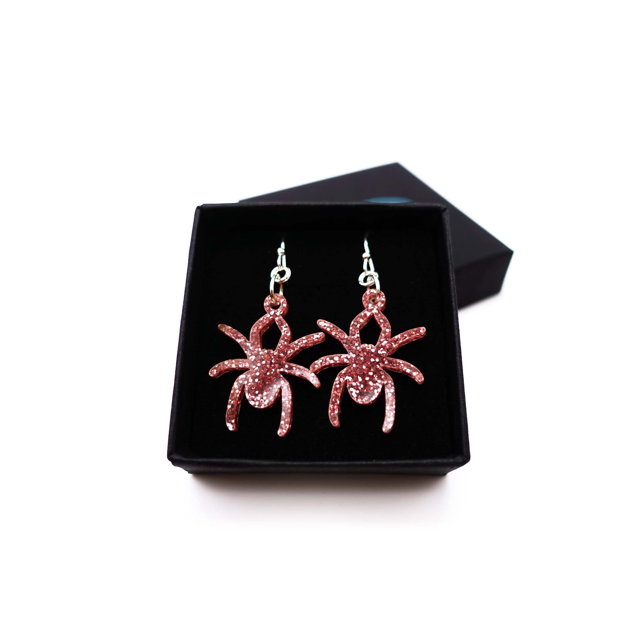 Lady Hale commemorative spider earrings in rose glitter shown in box.