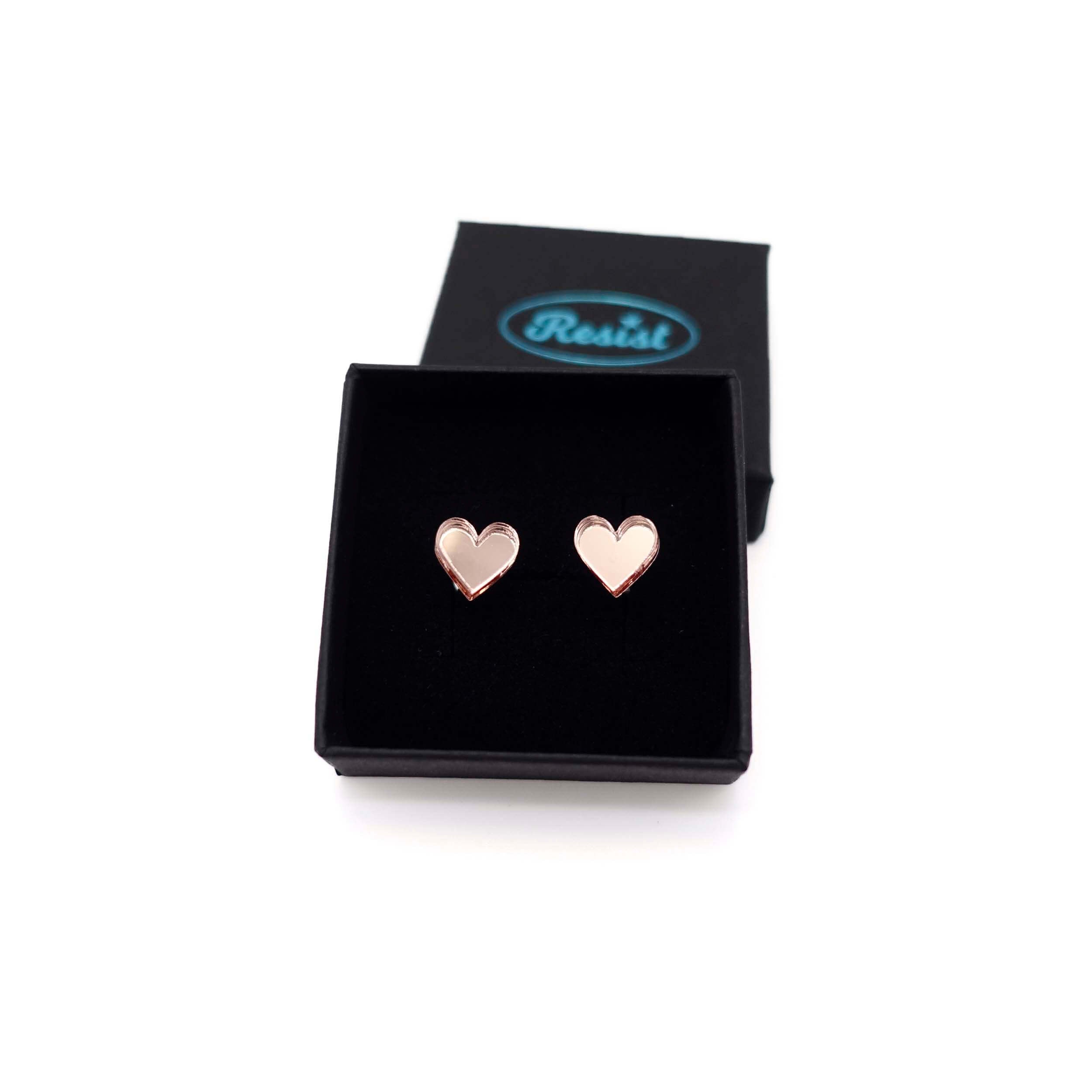 Rose gold mirror tiny heart stud earrings shown in a Wear and Resist gift box. 