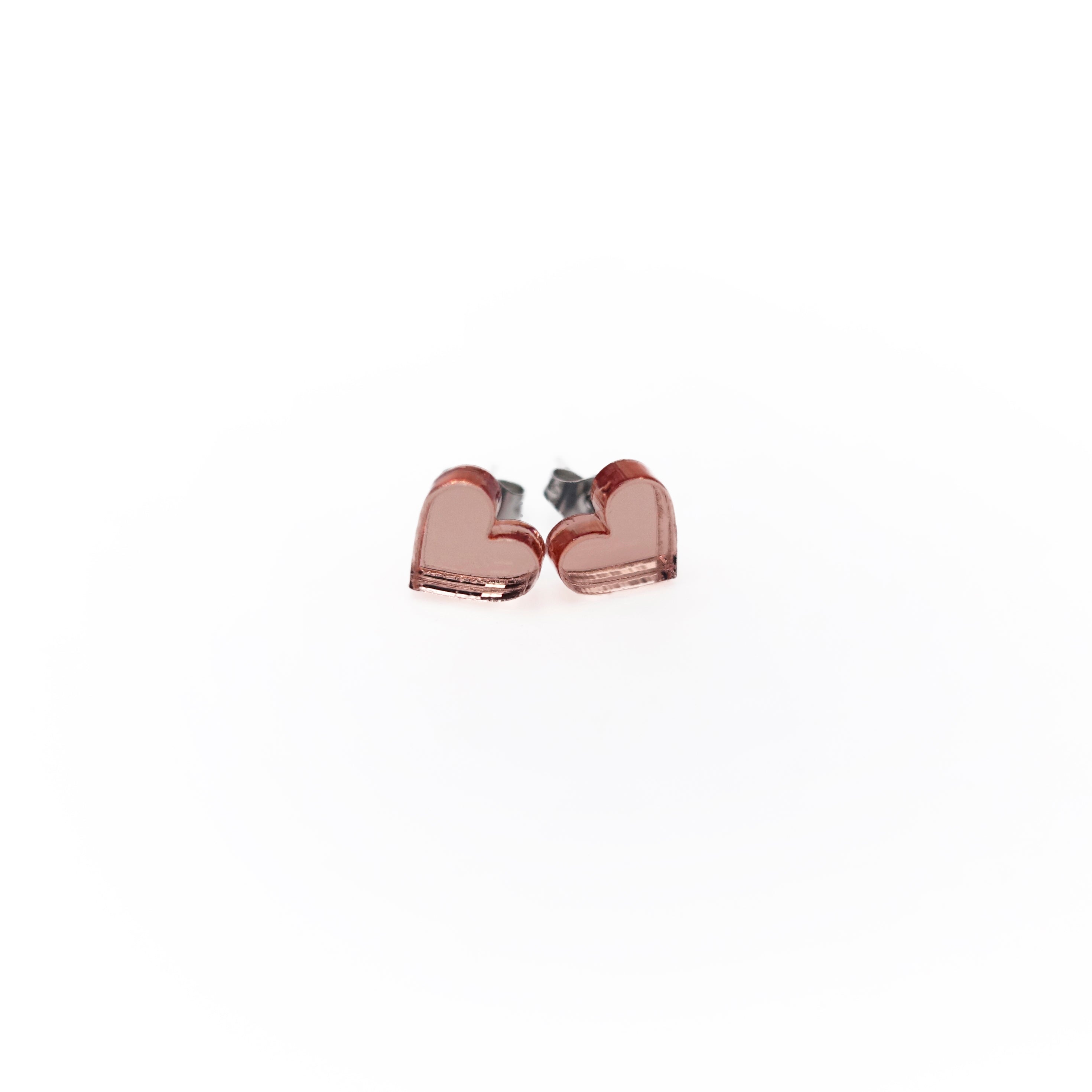 Rose gold mirror tiny heart stud earrings shown on a white background. 