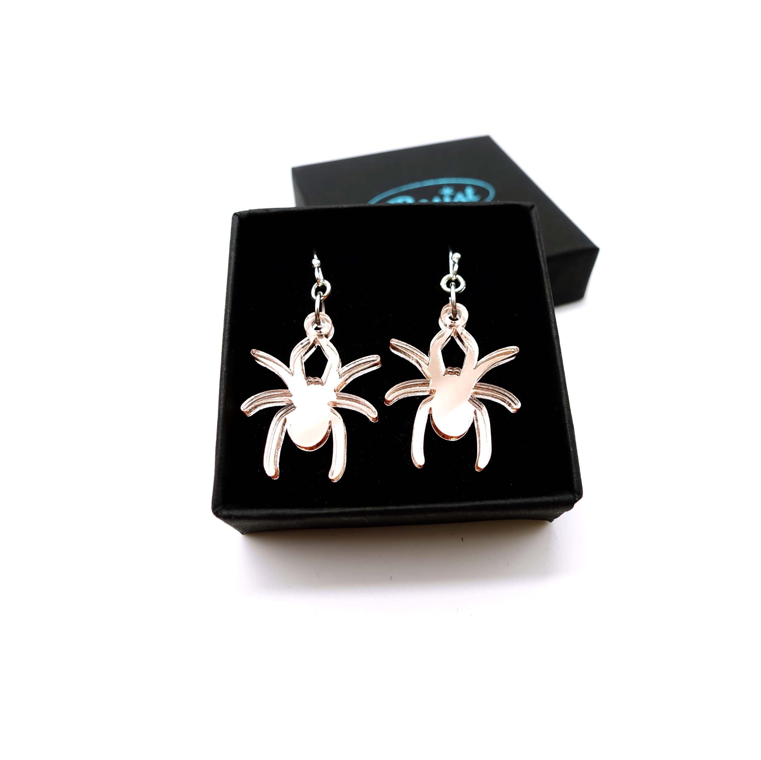 Lady Hale commemorative spider earrings in rose-gold mirror shown in box.