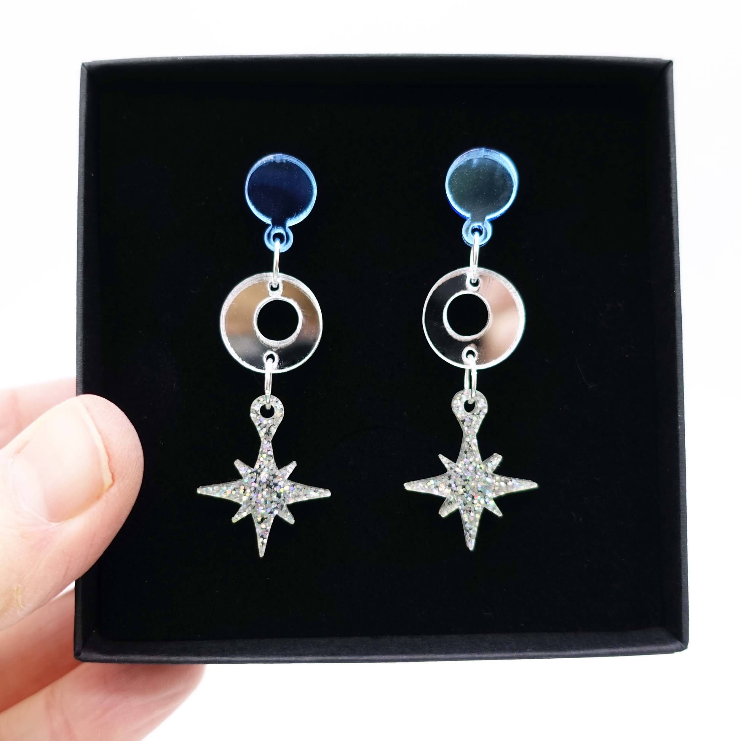 Cool silver Deco Star earrings shown held up in a Wear and Resist gift box. 