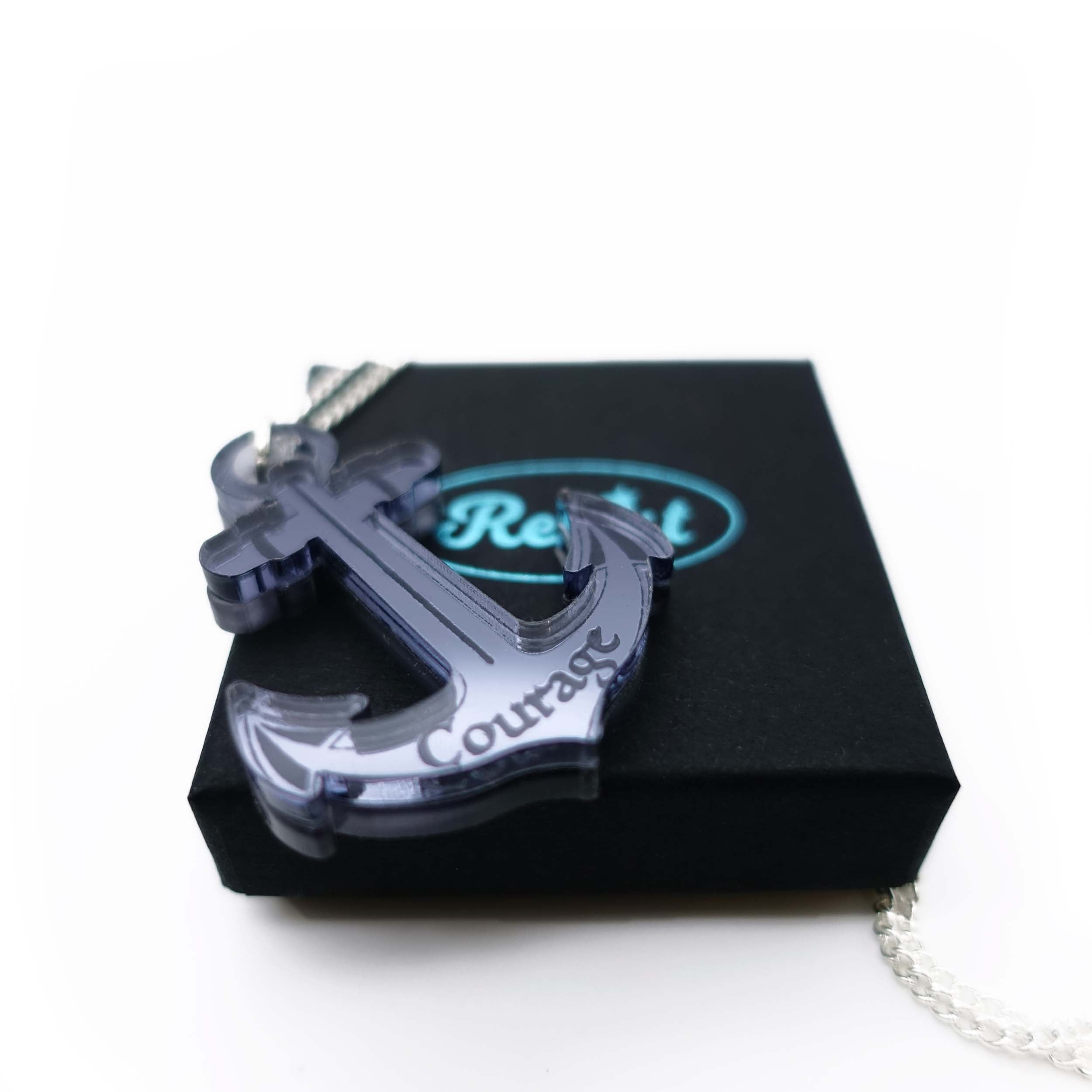 Slate mirror engraved courage anchor pendant shown on the small gift box. £4 from the sale of each will be split equally between the RNLI and Women for Refugee Women. 