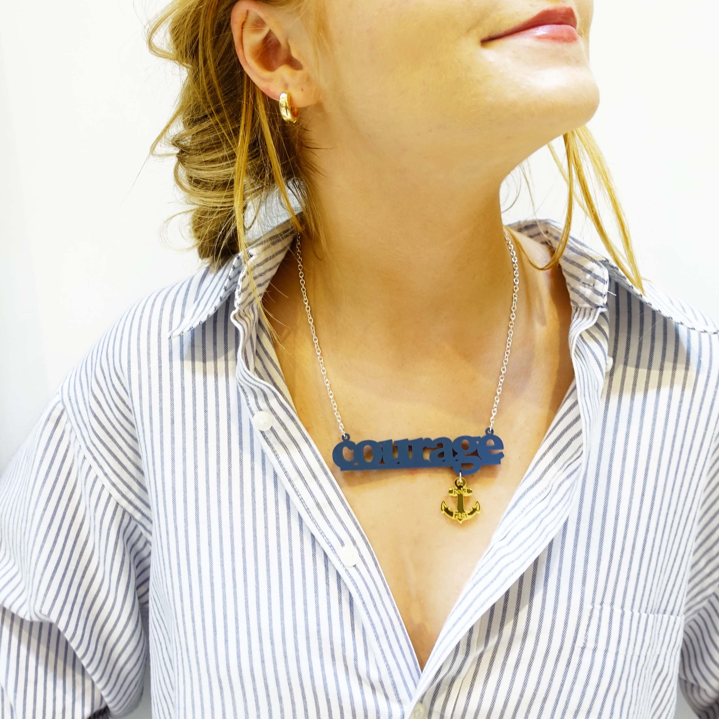 Model wears slate Courage necklace with gold hold fast anchor. 