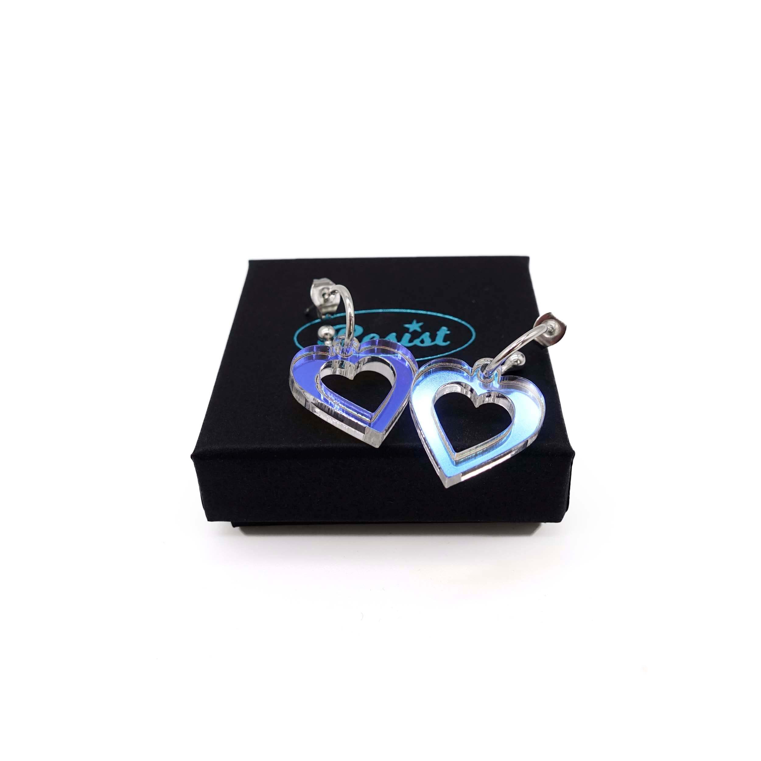 Small iridescent love heart hoop earrings shown on a Wear and Resist gift box. 
