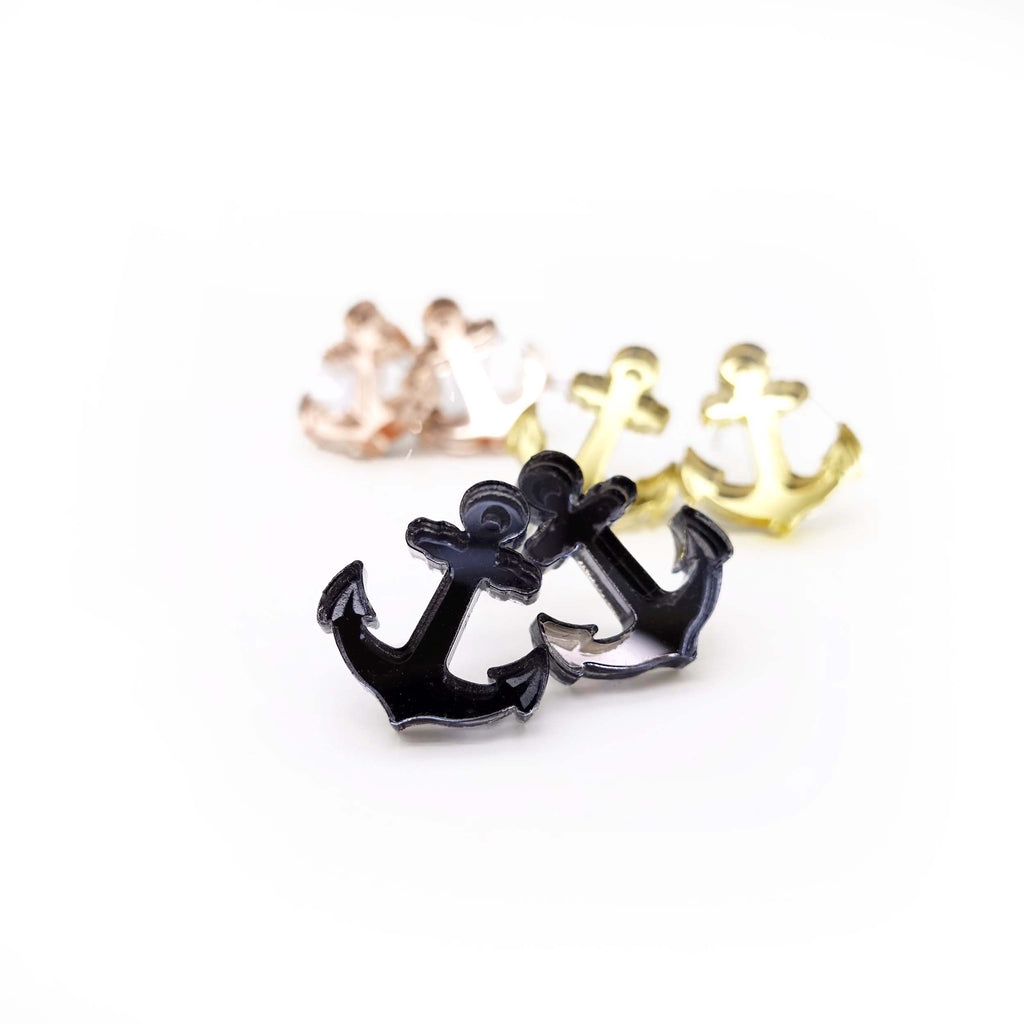 Set of three mirror colours tiny anchor stud earrings shown on a white background. 
