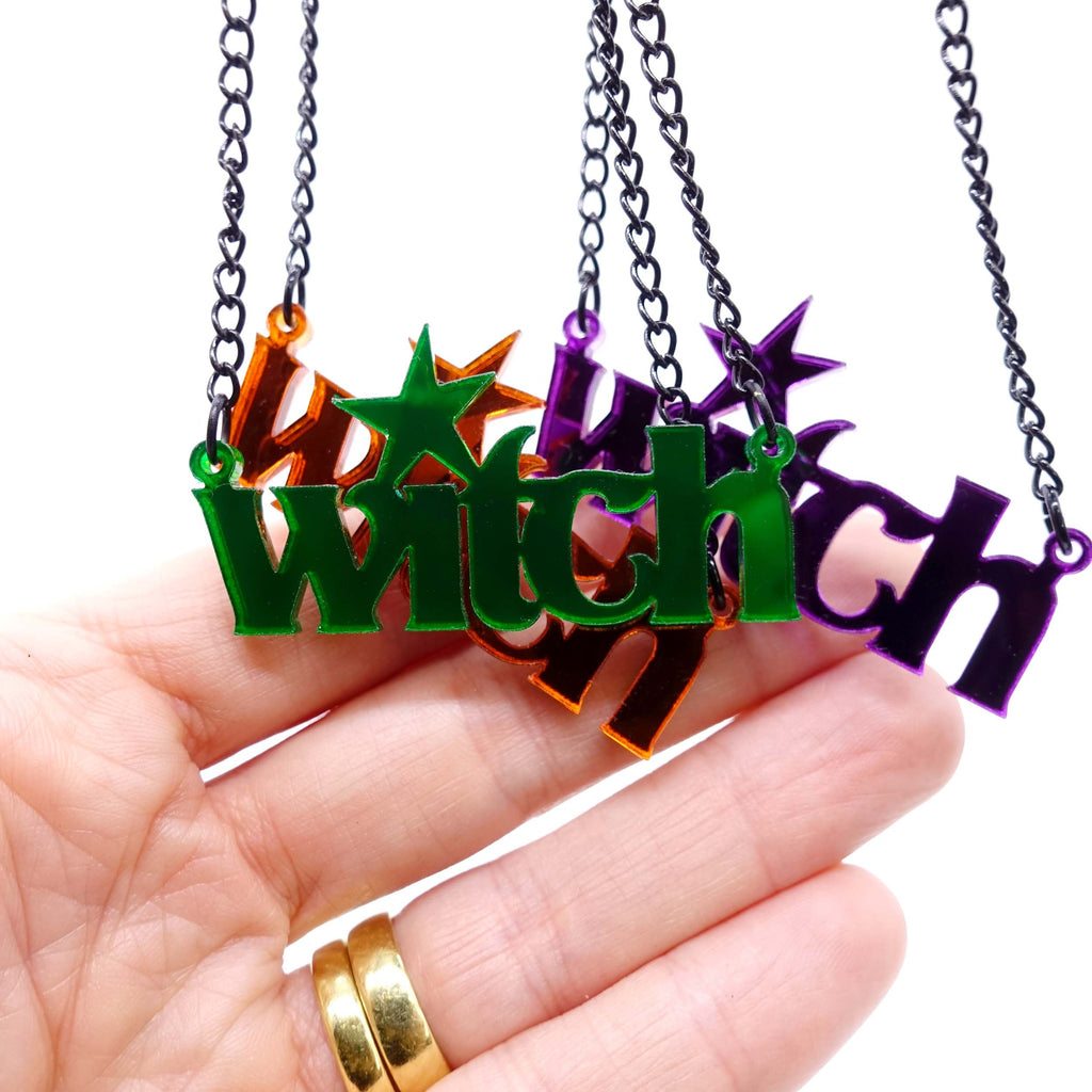 Three new Halloween colour witch necklaces shown hanging with a hand for scale. 