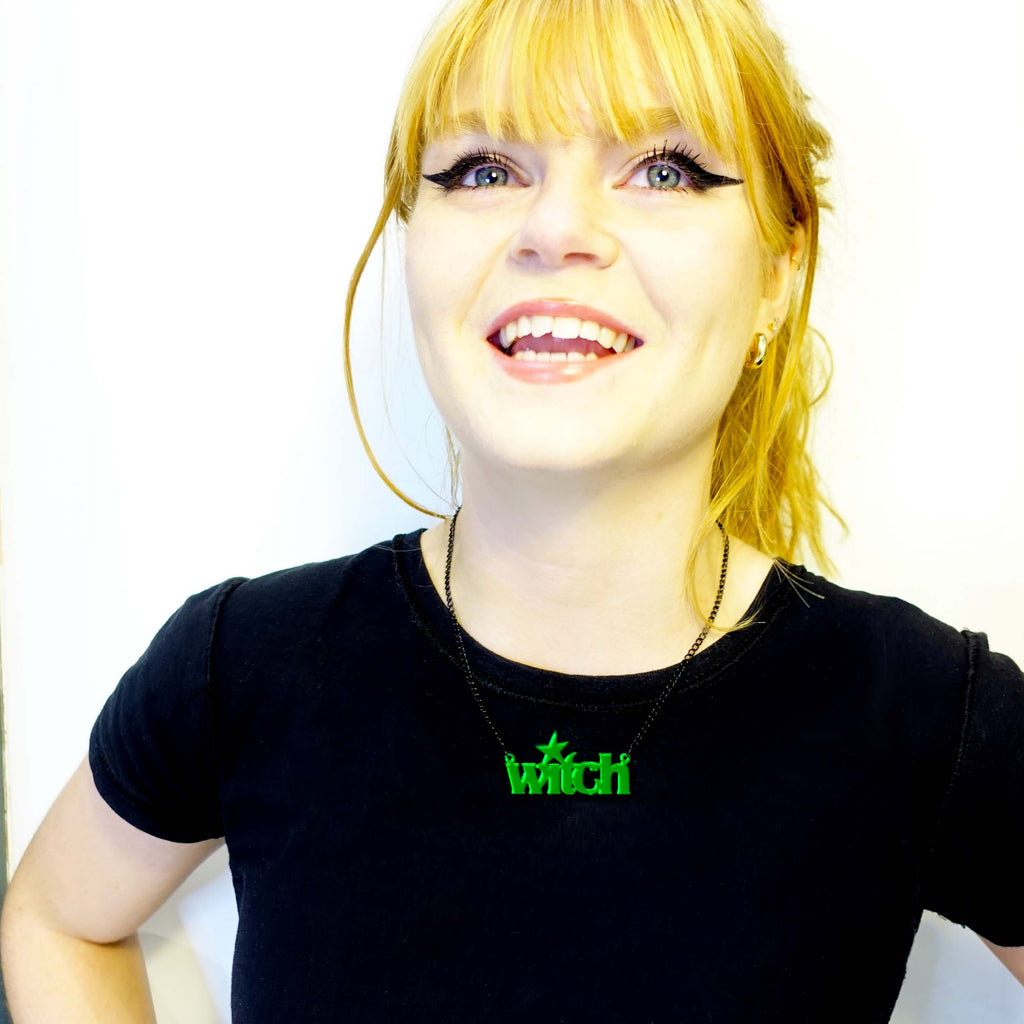 Model wearing absinthe green witch necklace laughing. 